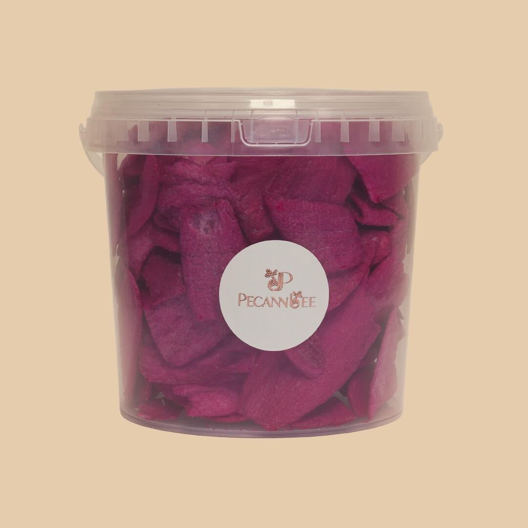 A transparent plastic tub filled with vibrant purple dehydrated onion slices, centered against a plain light beige background with a Pecanbee brand label