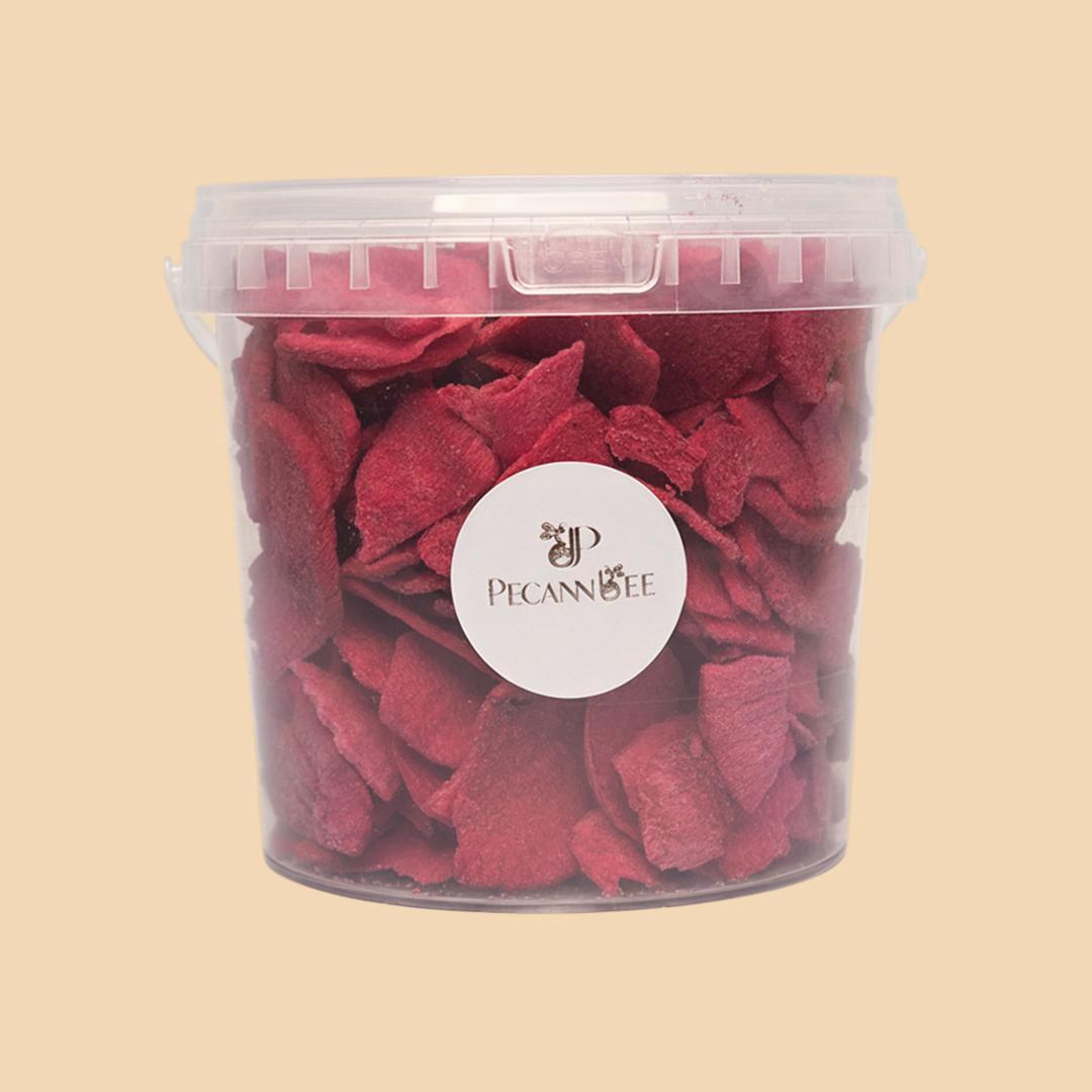 A clear plastic tub filled with dehydrated red radish slices, viewed from the front against a solid beige background, featuring a circular PecanBee brand sticke